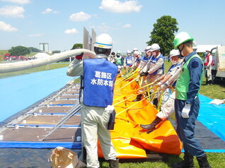 区職員による大型水のう注水状況の写真です。
